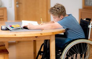 Boy In Wheelchair Doing Homework alunni disabili