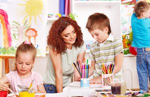 Child Painting At Easel.